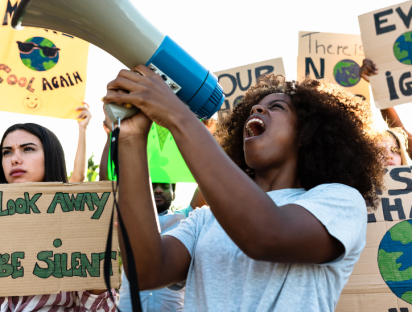 A woman during a demonstration against climate change illustrating a new policy brief by Camila Villard Duran on Innovative governance models for gender equality and climate action integration