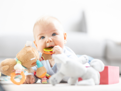 Un bébé sur un tapis de jeu avec des jouets sensoriels. Pédagogiques, ces jouets sont conçus pour aider les enfants à explorer leur environnement et à se préparer aux gestes de la vie quotidienne.