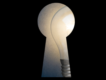 A light bulb, representing ideas, hidden and visible only through a keyhole.